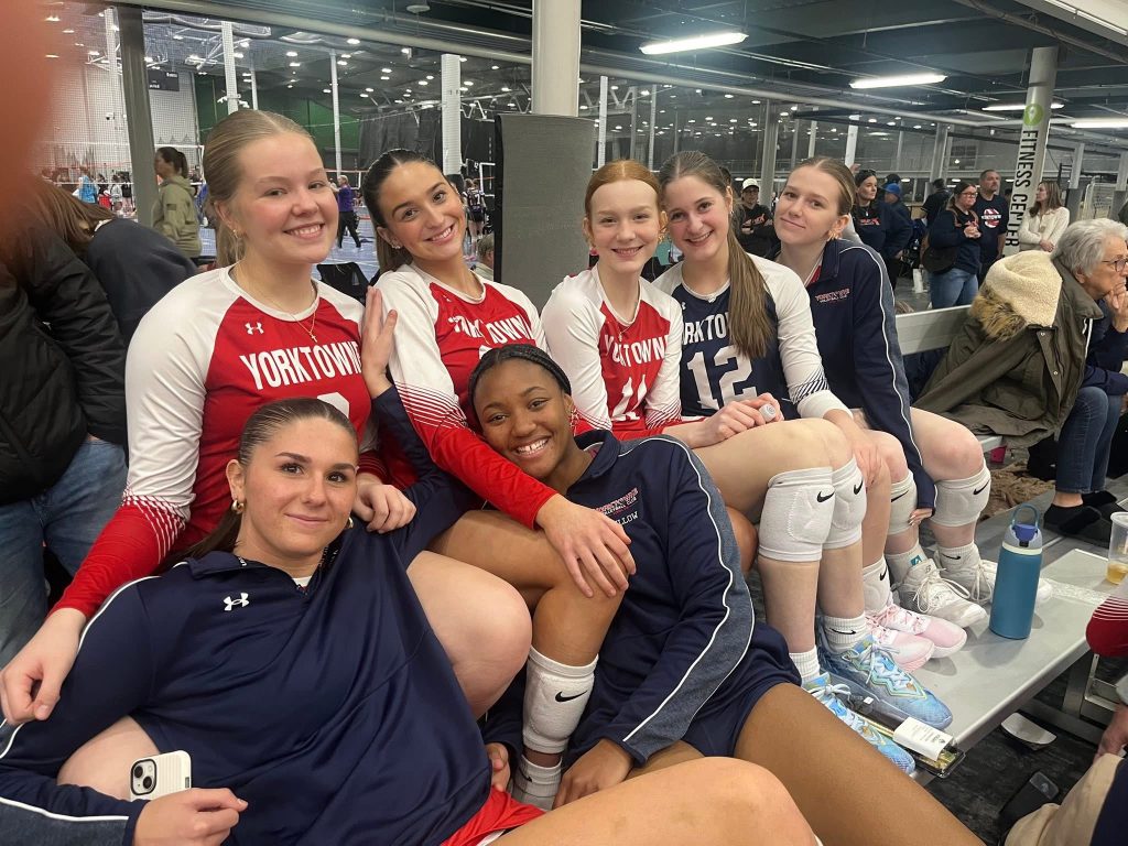 Yorktowne girls volleyball athletes sitting together between matches