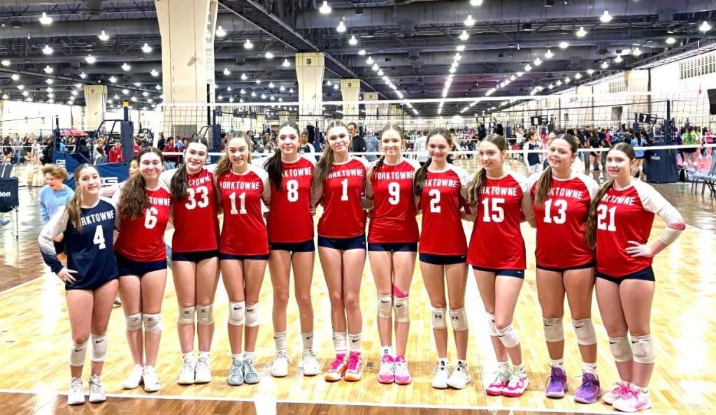 Girls volleyball athlete preparing to serve